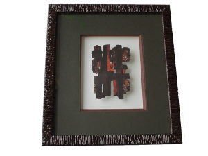 Encadrement d‘une reproduction de l‘Eau-Forte XI de P. SOULAGES. Le sujet est découpé et mis entre deux verres. Biseau droit sur le bord supérieur et le bord gauche. Biseau anglais sur le bord inférieur et sur le bord droit. Le passe-partout est positionné derrière les deux verres.